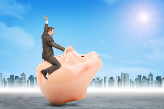 Businessman sitting on piggy bank on nature background