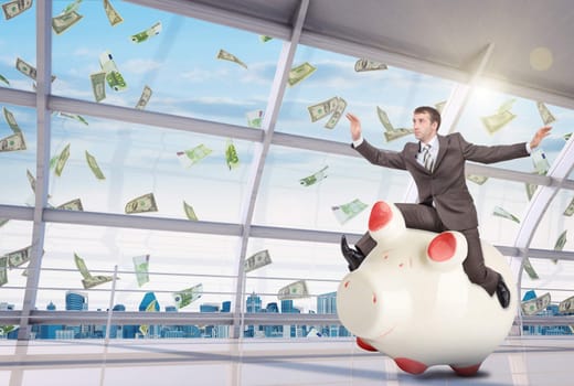 Businessman sitting on piggy bank on office background