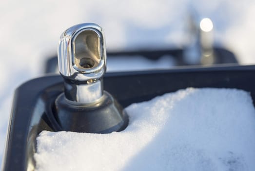 Drinking fountain with Snow and white/grey background.