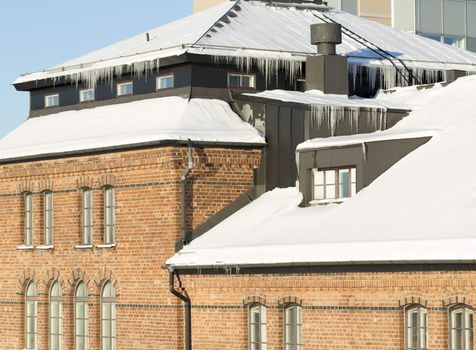 Icicles Hanging from Roof with snow in winter.