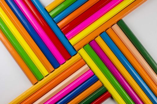 Abstract composition of a set wooden colour pencils against a white background
