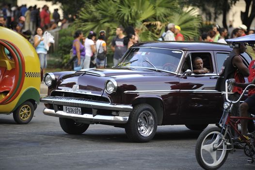 Old Havana, Cuba, -  August  2013. The old vintage-styled car in the historical center of Havana is waiting for the tourists to board. Riding an auto of the 20's - 50's is one of the attractions for the tourists in Cuba. Such cars are used for any goal, not only tourism, but taxis and personal needs.