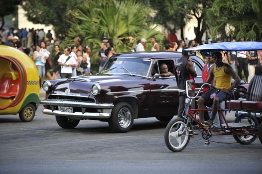 Old Havana, Cuba, -  August  2013. The old vintage-styled car in the historical center of Havana is waiting for the tourists to board. Riding an auto of the 20's - 50's is one of the attractions for the tourists in Cuba. Such cars are used for any goal, not only tourism, but taxis and personal needs.