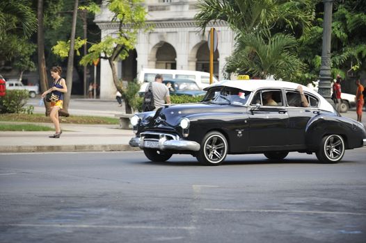 Old Havana, Cuba, -  August  2013. The old vintage-styled car in the historical center of Havana is waiting for the tourists to board. Riding an auto of the 20's - 50's is one of the attractions for the tourists in Cuba. Such cars are used for any goal, not only tourism, but taxis and personal needs.