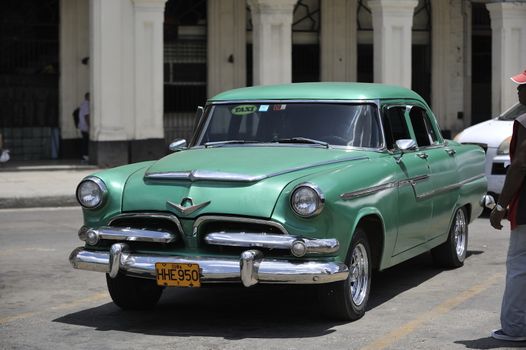 Old Havana, Cuba, -  August  2013. The old vintage-styled car in the historical center of Havana is waiting for the tourists to board. Riding an auto of the 20's - 50's is one of the attractions for the tourists in Cuba. Such cars are used for any goal, not only tourism, but taxis and personal needs.