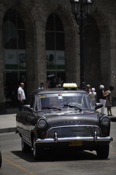 Old Havana, Cuba, -  August  2013. The old vintage-styled car in the historical center of Havana is waiting for the tourists to board. Riding an auto of the 20's - 50's is one of the attractions for the tourists in Cuba. Such cars are used for any goal, not only tourism, but taxis and personal needs.