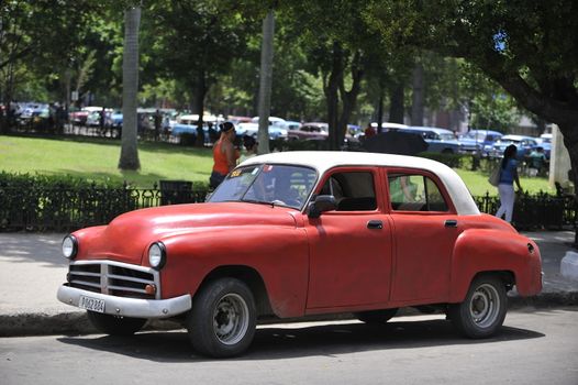 Old Havana, Cuba, -  August  2013. The old vintage-styled car in the historical center of Havana is waiting for the tourists to board. Riding an auto of the 20's - 50's is one of the attractions for the tourists in Cuba. Such cars are used for any goal, not only tourism, but taxis and personal needs.