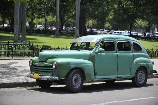 Old Havana, Cuba, -  August  2013. The old vintage-styled car in the historical center of Havana is waiting for the tourists to board. Riding an auto of the 20's - 50's is one of the attractions for the tourists in Cuba. Such cars are used for any goal, not only tourism, but taxis and personal needs.