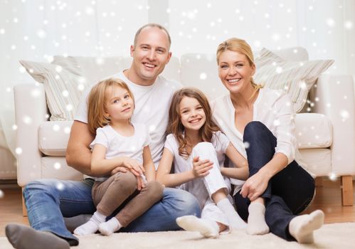 family, childhood, people and home concept - smiling parents with two little girls sitting on floor at home