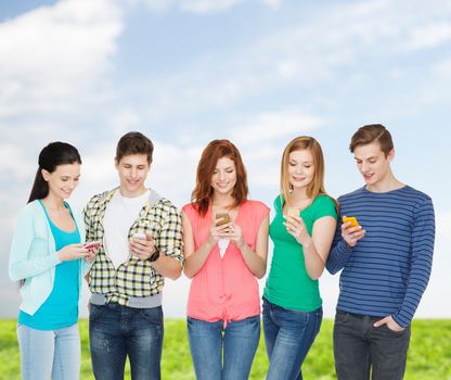 education and modern technology concept - smiling students with smartphones