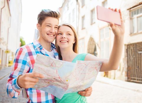 travel, vacation, technology and friendship concept - smiling couple with smartphone in city