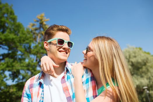 holidays, vacation, love and friendship concept - smiling couple having fun outdoors