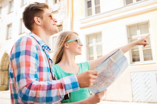 travel, vacation, technology and friendship concept - smiling couple with map and photo camera exploring city