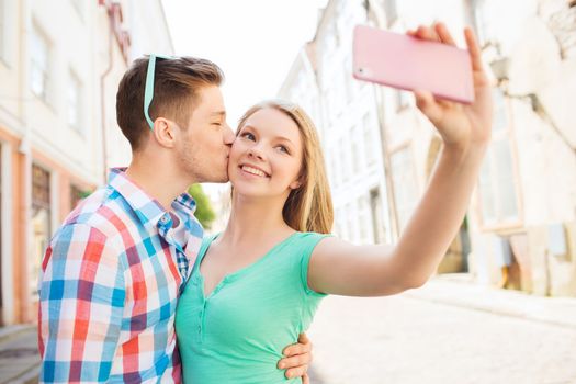 travel, vacation, technology and friendship concept - smiling couple with smartphone in city