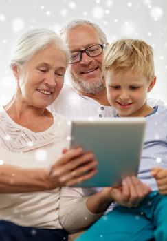 family, generation, technology and people concept - smiling grandparents and grandson with tablet pc computer at home