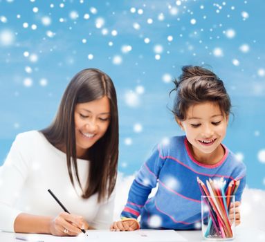 childhood, family, education and people concept - smiling little girl and mother or teacher drawing with coloring pencils over blue snowy sky with cloud background