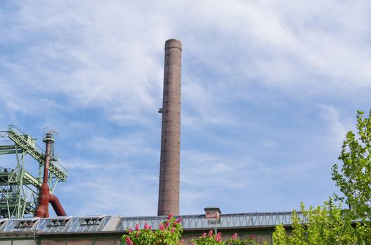 Chimney of an old factory against blue sky in the North Duisburg Landscape Park.