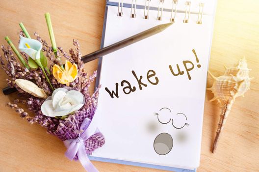 Wake up. Blank pencil on diary and flower in the morning time