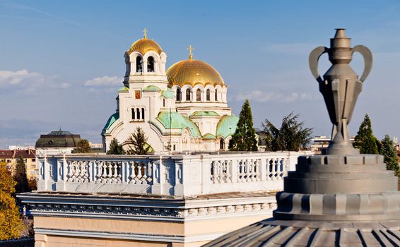 A view of golden domes st. Aleksander Nevski cathedral in Sofia, Bulgaria through a detail on a roof of a building. Horizontal image.