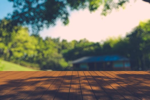 Beautiful sunlight in the autumn forest with wood planks floor, nature background, bokeh background