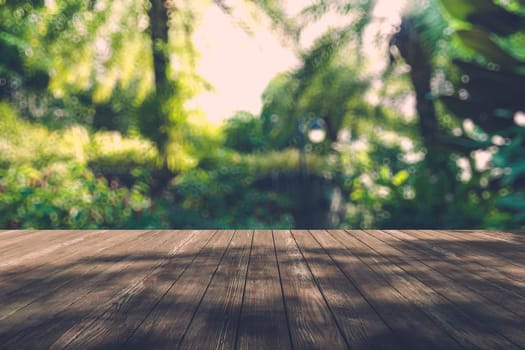 Beautiful sunlight in the autumn forest with wood planks floor, nature background, bokeh background