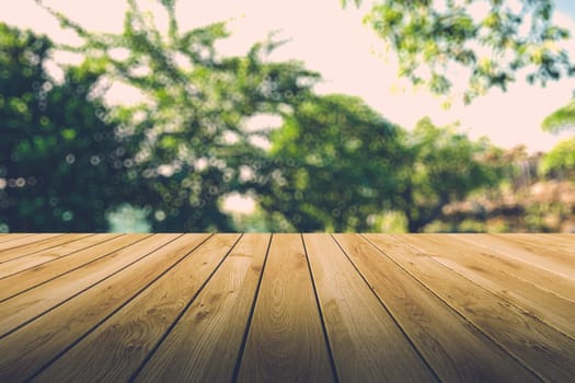 Beautiful sunlight in the autumn forest with wood planks floor, nature background, bokeh background