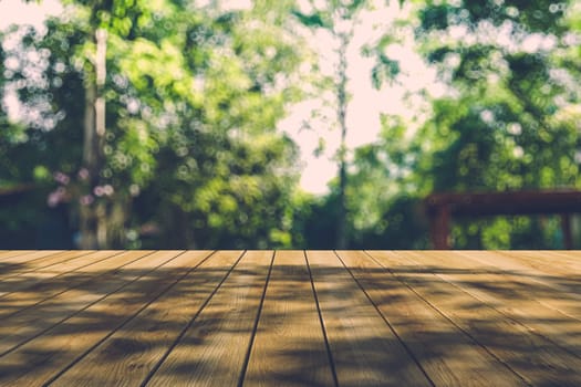 Beautiful sunlight in the autumn forest with wood planks floor, nature background, bokeh background