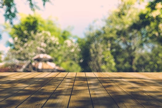 Beautiful sunlight in the autumn forest with wood planks floor, nature background, bokeh background