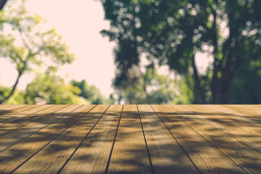 Beautiful sunlight in the autumn forest with wood planks floor, nature background, bokeh background