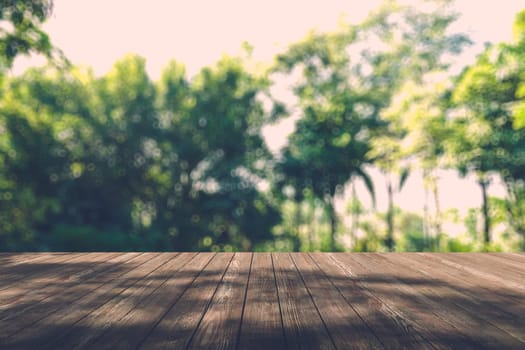 Beautiful sunlight in the autumn forest with wood planks floor, nature background, bokeh background