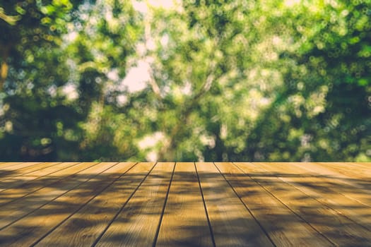 Beautiful sunlight in the autumn forest with wood planks floor, nature background, bokeh background