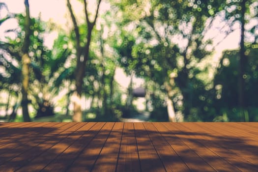 Beautiful sunlight in the autumn forest with wood planks floor, nature background, bokeh background