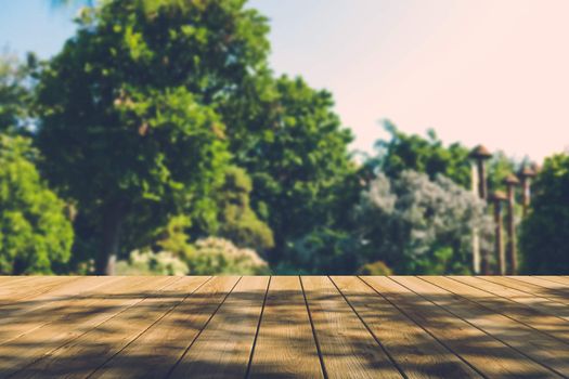 Beautiful sunlight in the autumn forest with wood planks floor, nature background, bokeh background