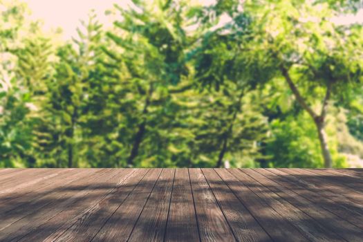 Beautiful sunlight in the autumn forest with wood planks floor, nature background, bokeh background