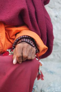 Old monk's hand with prayer beads.