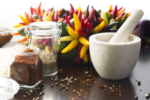 Fresh colorful chili peppers and ground chili pepper with mortar and pestle.