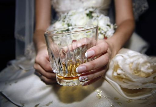 Glass of whiskey in a hand of the bride