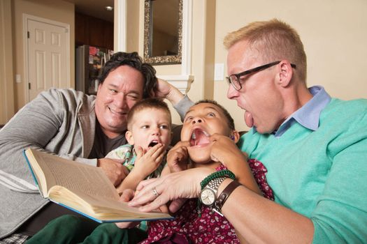 Diverse same sex parents with children reading together