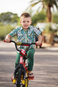 Cute child happily riding a bicycle on road