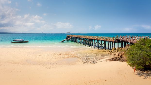 Pictured turquoise Indian Ocean and a beautiful wooden pier built on the shores of Prison Island in Zanzibar, Tanzania