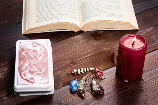 Composition of esoteric objects,candle,cards and book used for healing and fortune-telling.