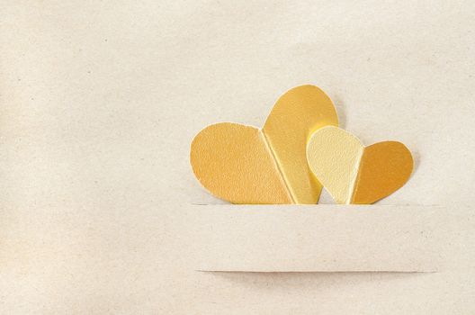 Gold heart on vintage brown paper background with copy space