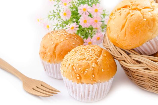 Bread bun with white sesame seeds and wooden spoon on white background