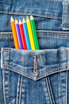 Artist painting concept. Many color pencil in blue jeans pocket background.