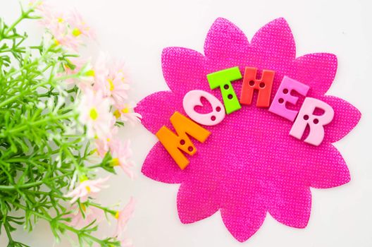 I love mom concept. Mother made from alphabet on pink paper with flower.