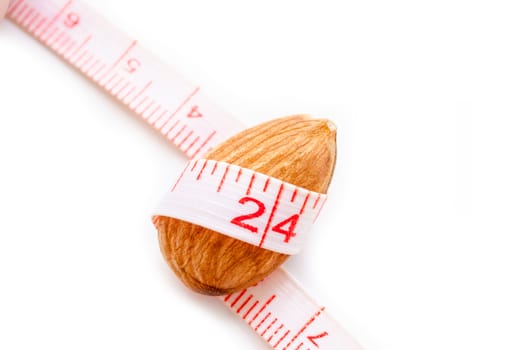 Almond nut and measure tape on white background, Diet concept.