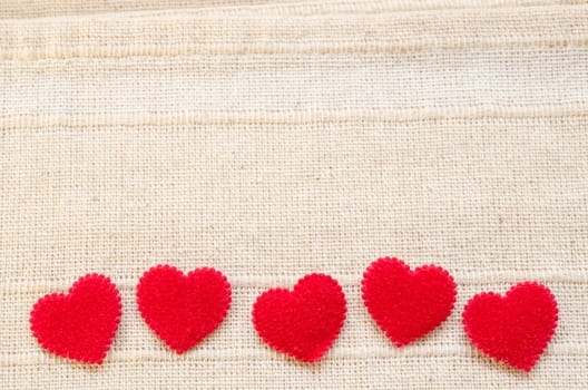 Red heart fabric on vintage fabric background with empty space. Love concept background.