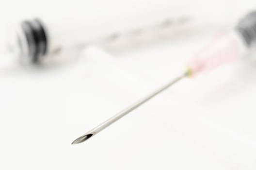 Medical needle and syringe on white background.