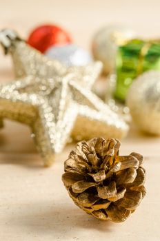 The gold cones with christmas decorations on wood background.