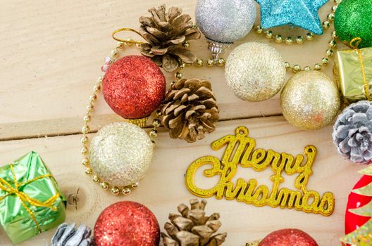 The words Merry Christmas with christmas decorations on wood background.